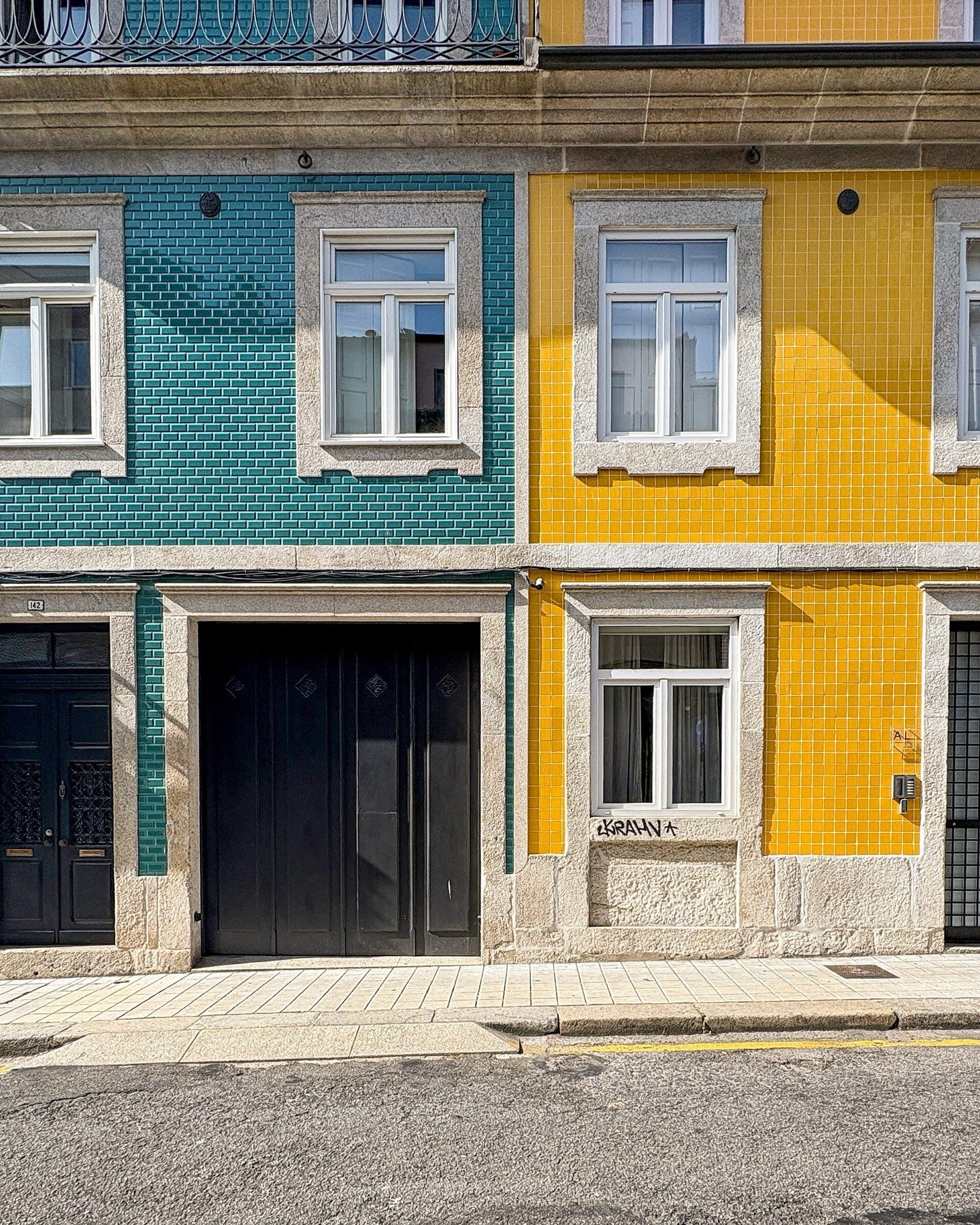 Duas casas vizinhas no Porto, uma em azulejo verde e outra em azulejo amarelo